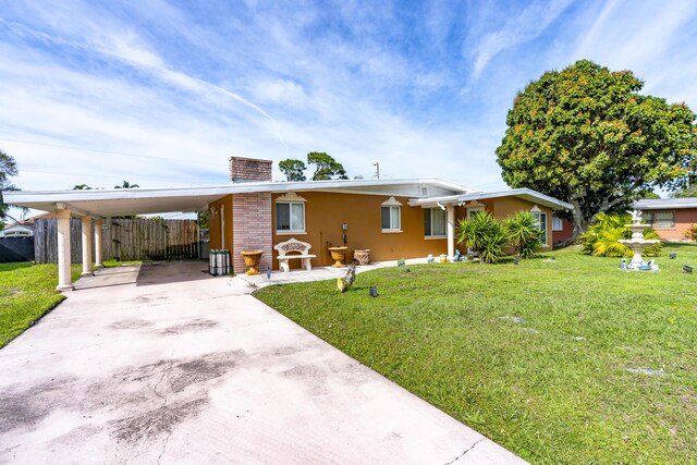 view of front of property with a carport and a front lawn