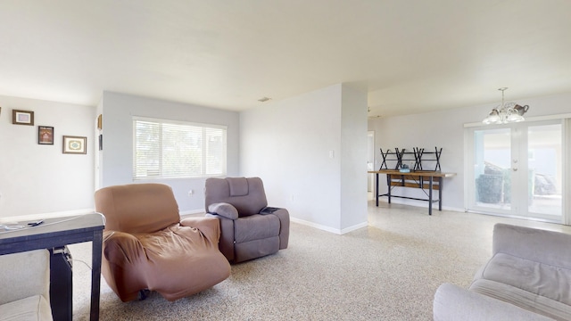living room with visible vents, baseboards, light speckled floor, and a chandelier