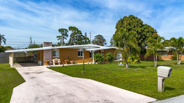 ranch-style home featuring a front yard and a carport