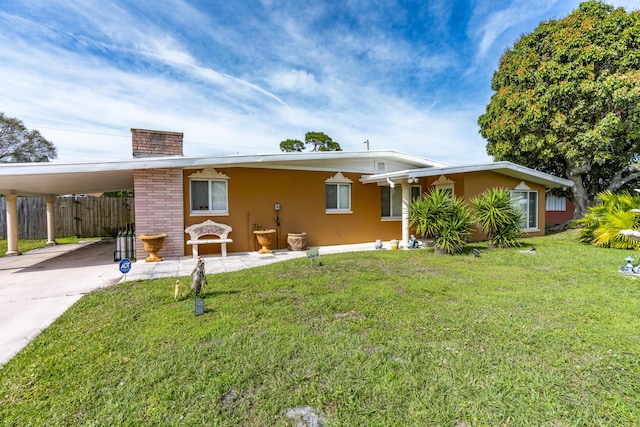 view of front of property featuring an attached carport, driveway, fence, a front yard, and stucco siding