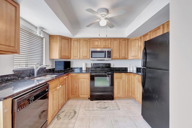 kitchen featuring sink, light tile patterned floors, dark stone countertops, black appliances, and a raised ceiling