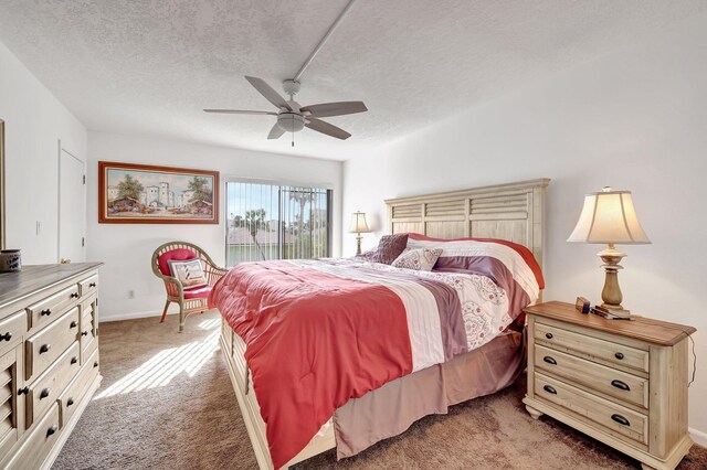 carpeted bedroom with ceiling fan and a textured ceiling