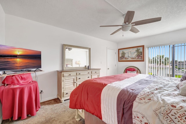 bedroom featuring ceiling fan, light colored carpet, and a textured ceiling