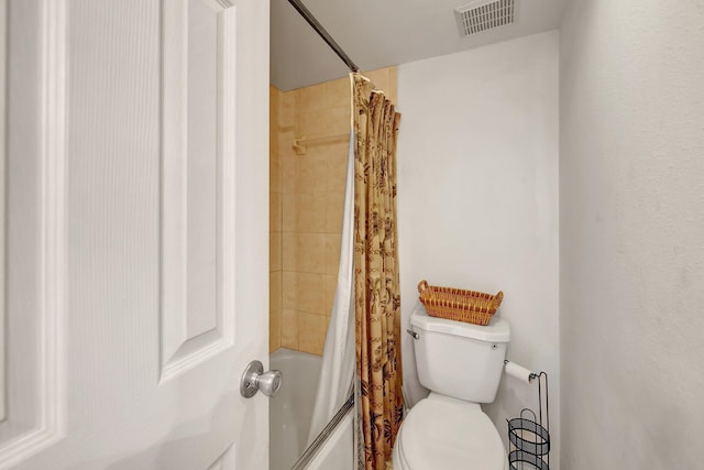 bathroom featuring shower / bath combination with curtain and toilet