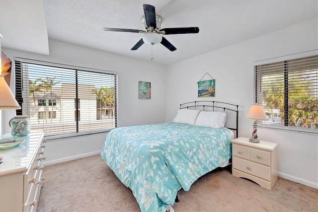 carpeted bedroom featuring a textured ceiling and ceiling fan