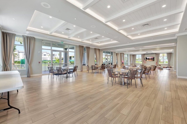 dining space featuring beamed ceiling, a tray ceiling, and light hardwood / wood-style flooring