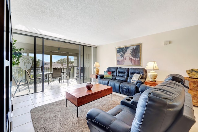 tiled living room featuring a textured ceiling and a wall of windows