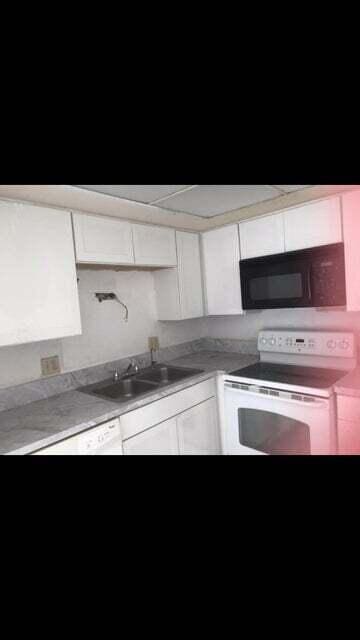 kitchen with white electric range oven, sink, and white cabinets