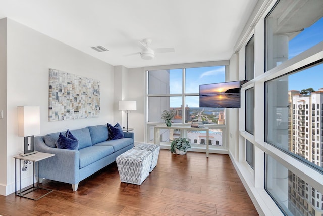 living room featuring dark wood-type flooring and ceiling fan