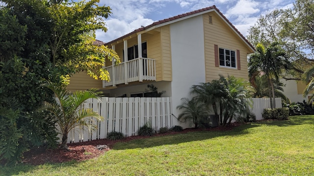 view of home's exterior featuring a yard and a balcony