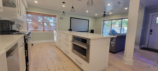 kitchen with white cabinetry, a center island, light hardwood / wood-style flooring, appliances with stainless steel finishes, and pendant lighting