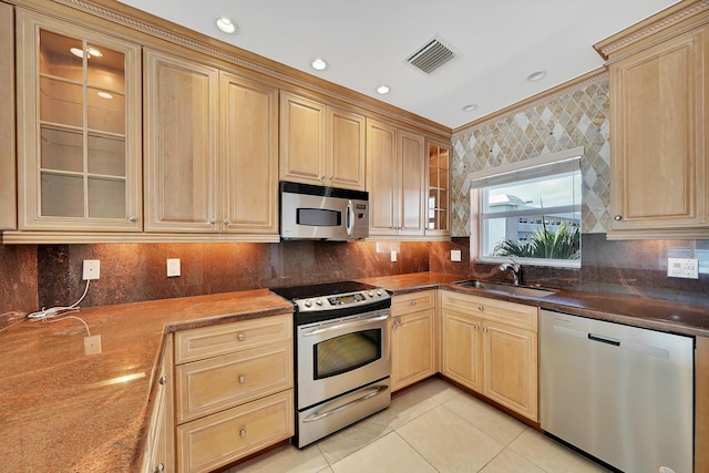 kitchen with light tile patterned floors, visible vents, appliances with stainless steel finishes, light brown cabinets, and a sink