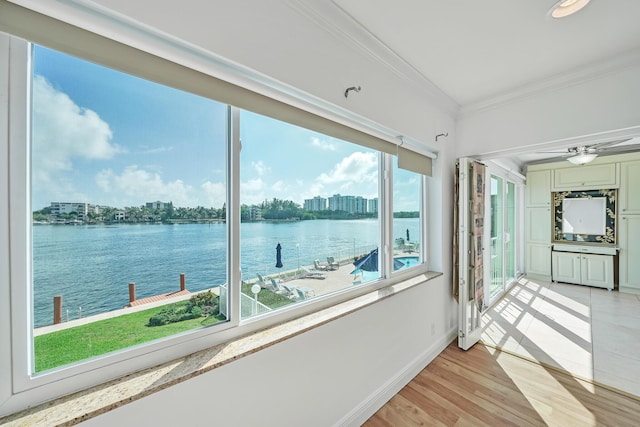 sunroom / solarium featuring a water view and ceiling fan