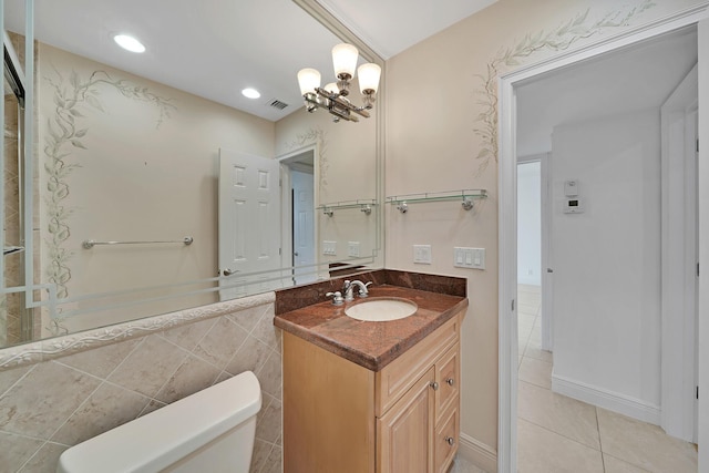 bathroom featuring tile walls, visible vents, toilet, vanity, and tile patterned floors