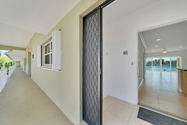 entrance to property with a water view and stucco siding