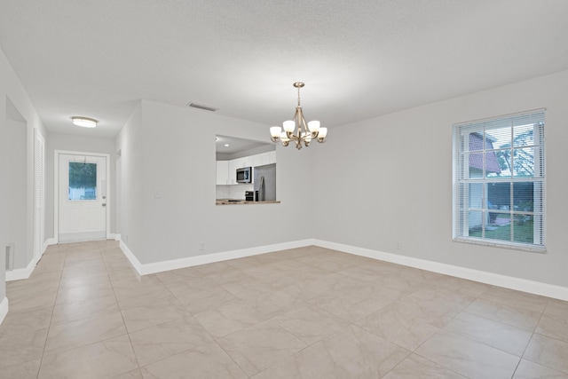 spare room with a chandelier