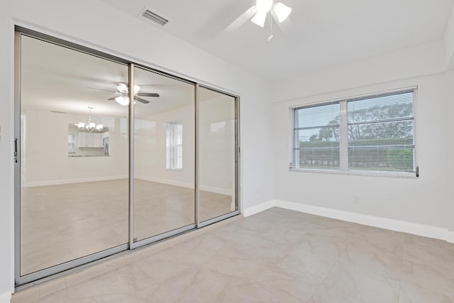 unfurnished bedroom with ceiling fan with notable chandelier and a closet