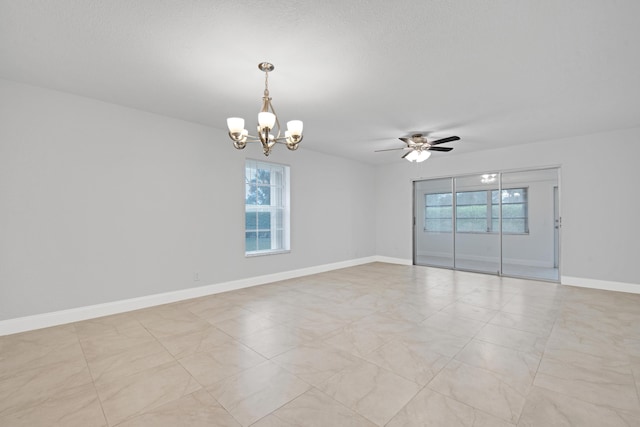 empty room featuring ceiling fan with notable chandelier