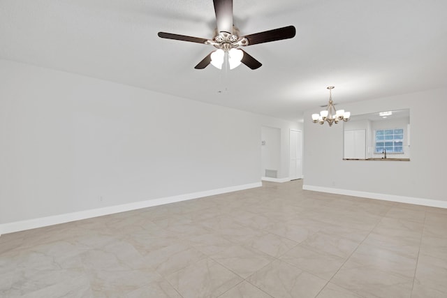 spare room featuring sink and ceiling fan with notable chandelier