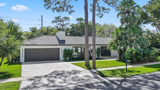 view of front of house with a garage and a front lawn