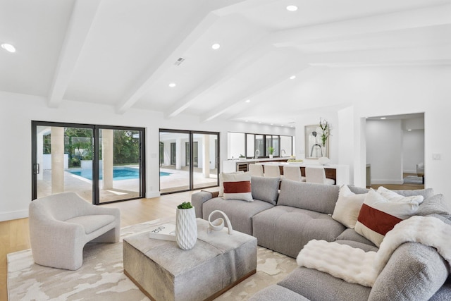 living room with lofted ceiling with beams and light wood-type flooring