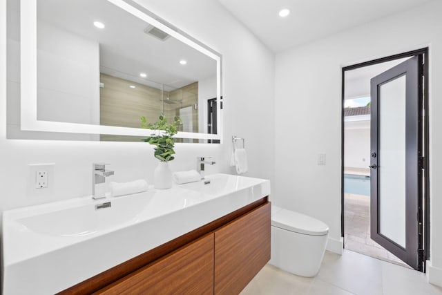 bathroom with a shower with door, vanity, tile patterned floors, and toilet