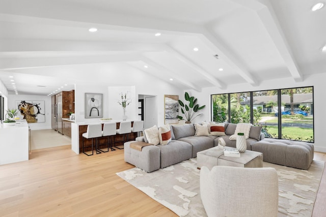 living room with vaulted ceiling with beams and light hardwood / wood-style flooring