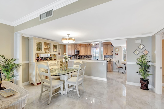 dining space with crown molding and decorative columns