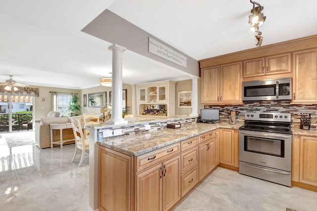 kitchen featuring ornate columns, decorative backsplash, light stone counters, kitchen peninsula, and stainless steel appliances