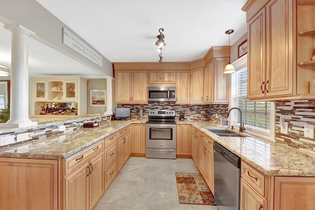 kitchen featuring pendant lighting, sink, appliances with stainless steel finishes, kitchen peninsula, and ornate columns