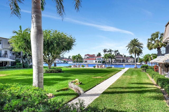 view of home's community with a water view and a lawn