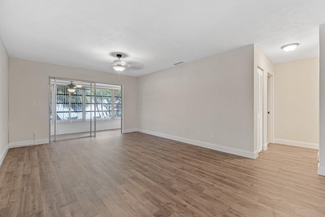 unfurnished room with a textured ceiling, ceiling fan, and light wood-type flooring