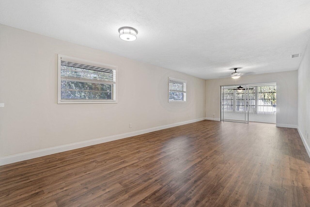 unfurnished room featuring dark wood-type flooring, a textured ceiling, and ceiling fan