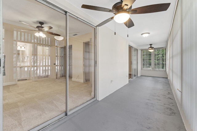 interior space featuring ceiling fan and concrete flooring