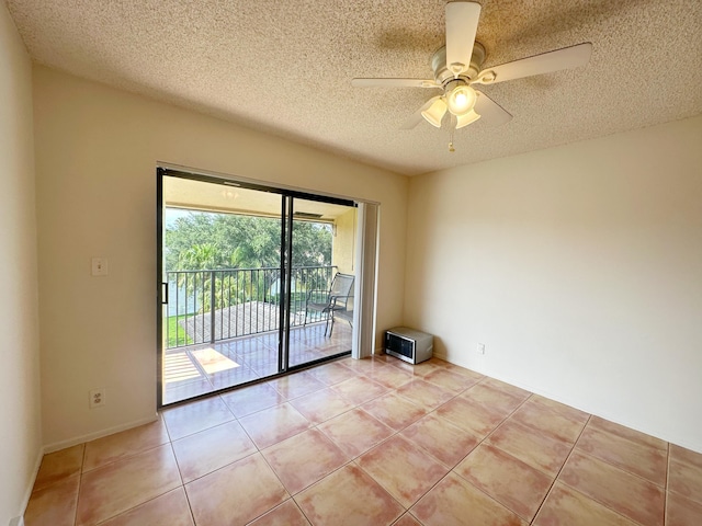 tiled empty room featuring ceiling fan and a textured ceiling