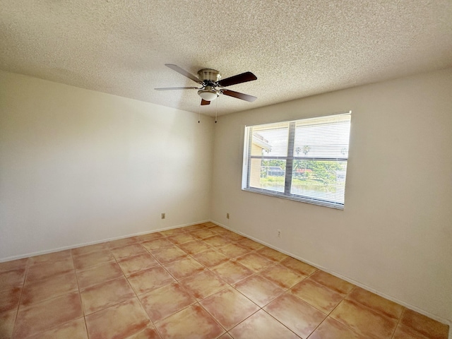 tiled empty room featuring ceiling fan and a textured ceiling