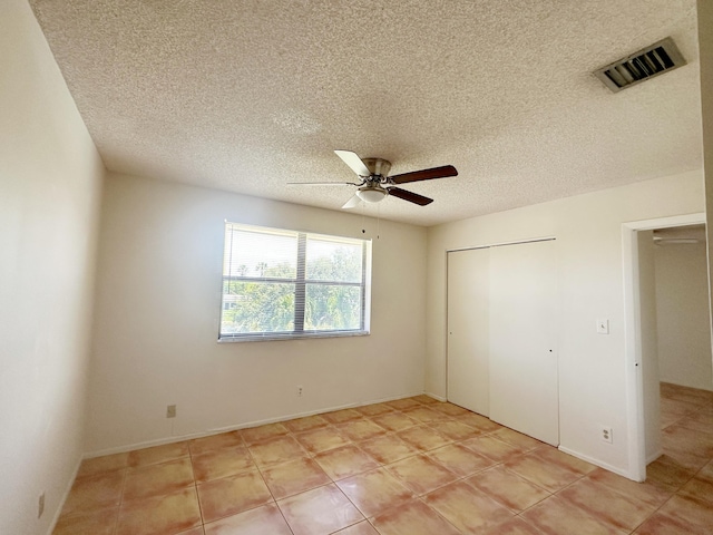 unfurnished bedroom featuring ceiling fan and a textured ceiling