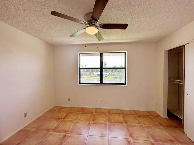 unfurnished bedroom with light tile patterned floors, a textured ceiling, and ceiling fan