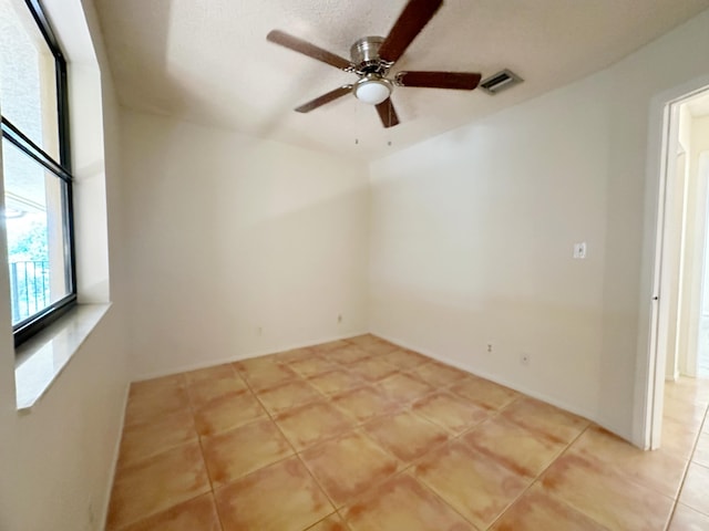 spare room featuring ceiling fan and light tile patterned floors