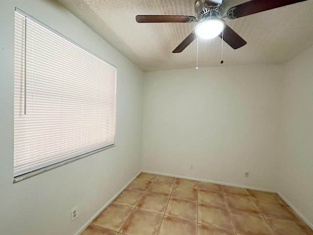 spare room with light tile patterned flooring and a textured ceiling