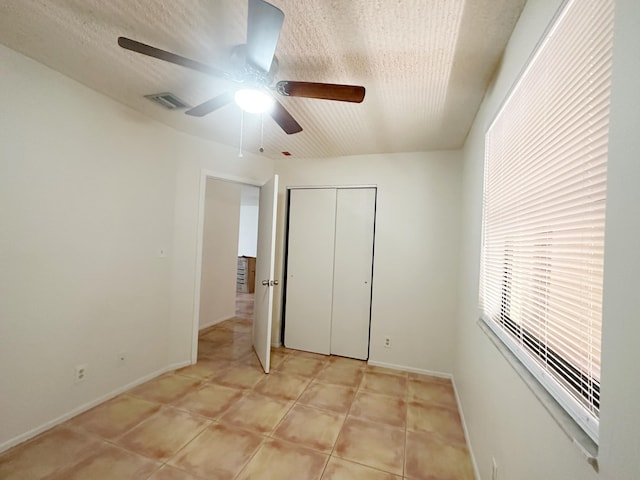 unfurnished bedroom featuring light tile patterned flooring, ceiling fan, and a closet