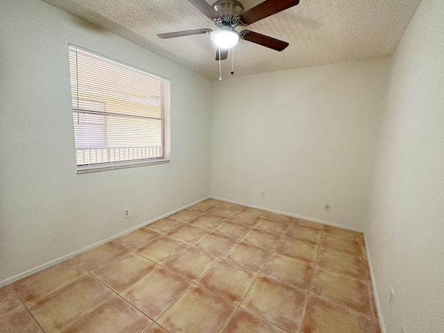 tiled empty room with ceiling fan and a textured ceiling