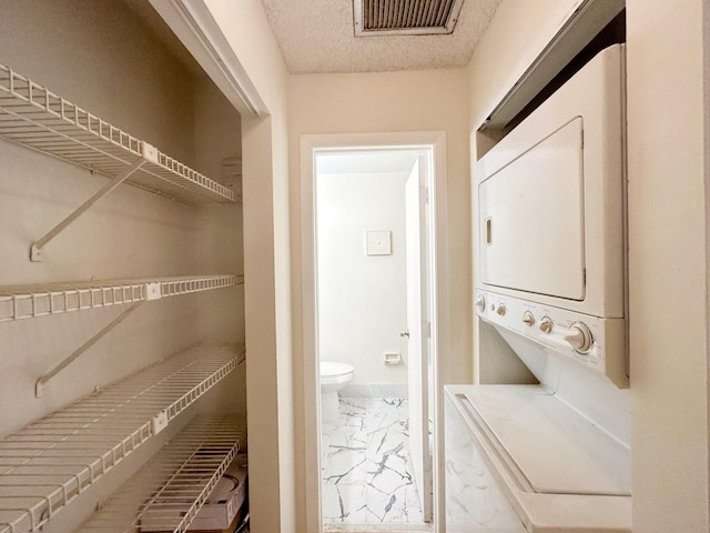 clothes washing area featuring stacked washer and dryer