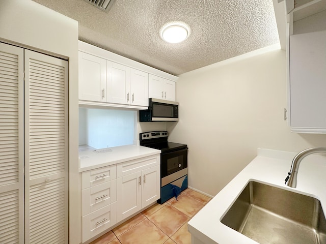 kitchen featuring range with electric stovetop, light tile patterned flooring, sink, and white cabinets