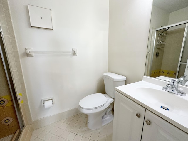 bathroom with vanity, a shower with shower door, tile patterned floors, and toilet