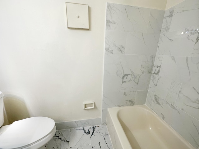 bathroom featuring tiled shower / bath and toilet