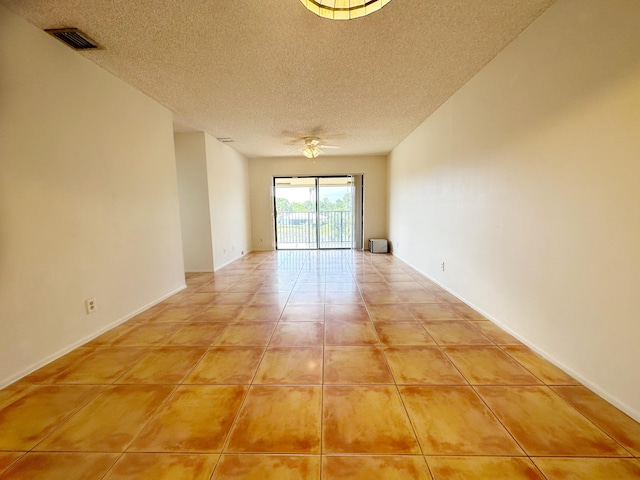 tiled spare room with ceiling fan and a textured ceiling