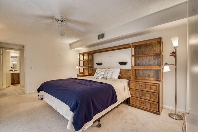 carpeted bedroom with connected bathroom, a textured ceiling, and ceiling fan