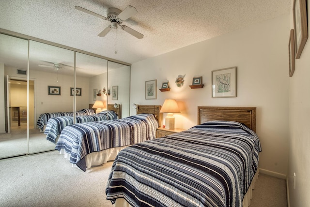 carpeted bedroom featuring ceiling fan, a closet, and a textured ceiling