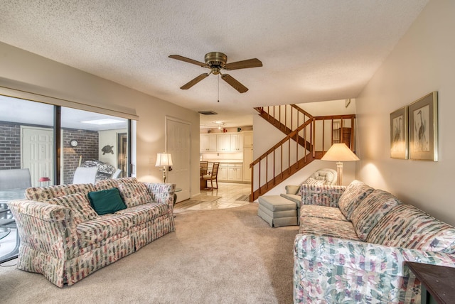 living room featuring light carpet, ceiling fan, and a textured ceiling